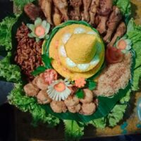 Foto nasi tumpeng khas Kajen yang lezat, disajikan dengan lauk pauk lengkap dan garnish tradisional, siap untuk dinikmati dalam acara spesial.