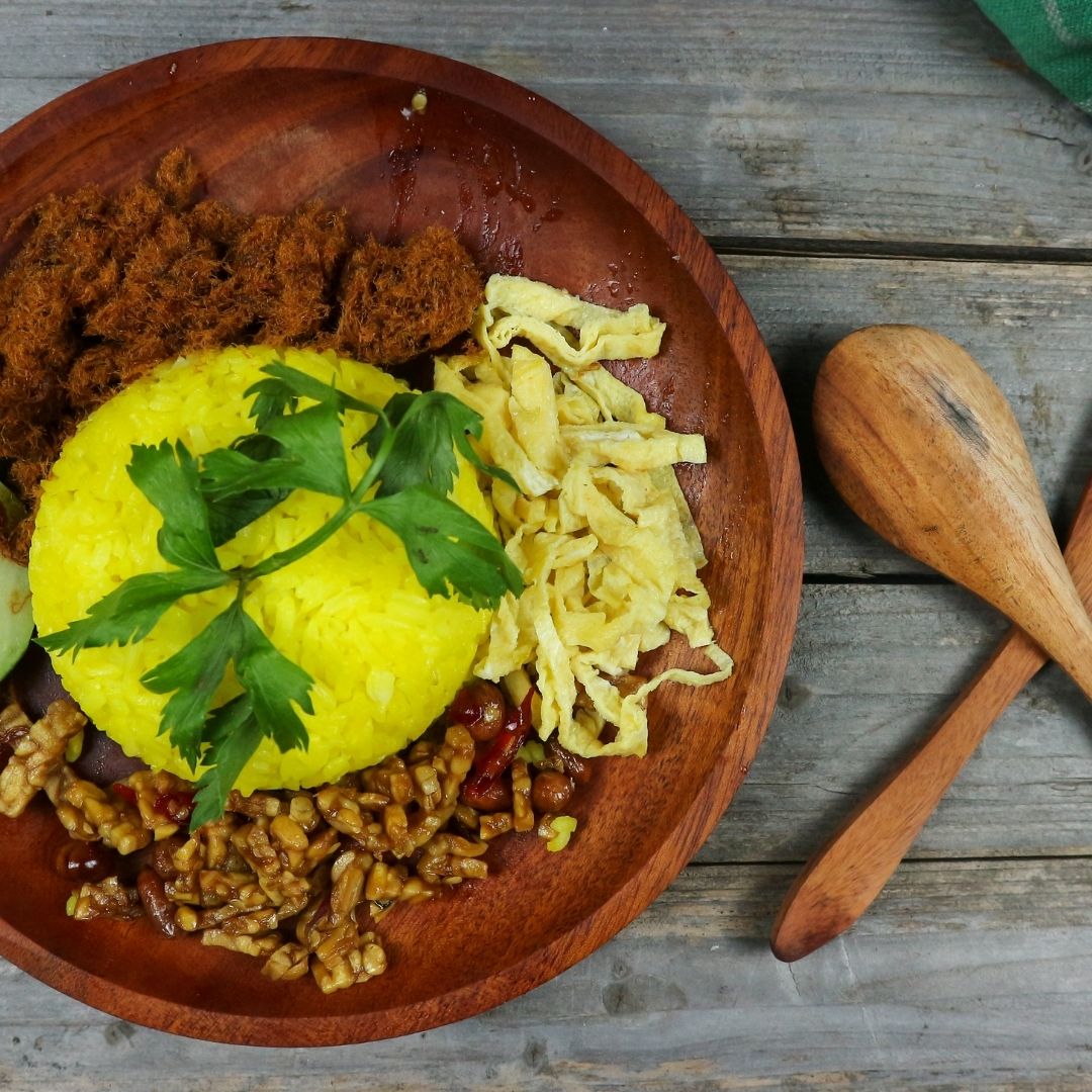 Foto nasi tumpeng khas Demak yang lezat, disajikan dengan lauk pauk lengkap dan garnish tradisional, siap untuk dinikmati dalam acara spesial.