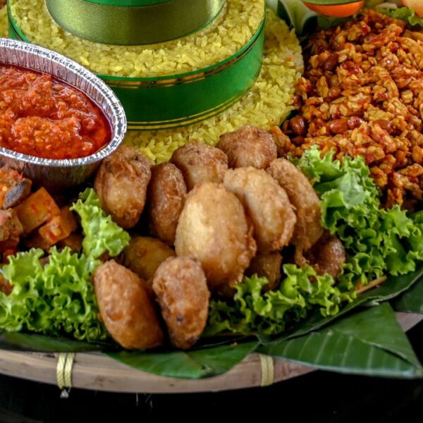 Foto nasi tumpeng khas Pituruh yang lezat, disajikan dengan lauk pauk lengkap dan garnish tradisional, siap untuk dinikmati dalam acara spesial.