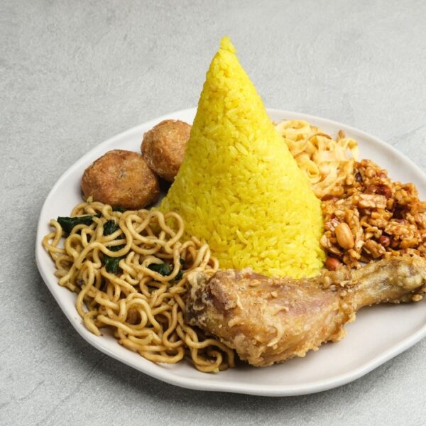 Foto nasi tumpeng khas Loano yang lezat, disajikan dengan lauk pauk lengkap dan garnish tradisional, siap untuk dinikmati dalam acara spesial.