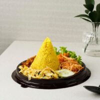 Foto nasi tumpeng khas Kokap yang lezat, disajikan dengan lauk pauk lengkap dan garnish tradisional, siap untuk dinikmati dalam acara spesial.