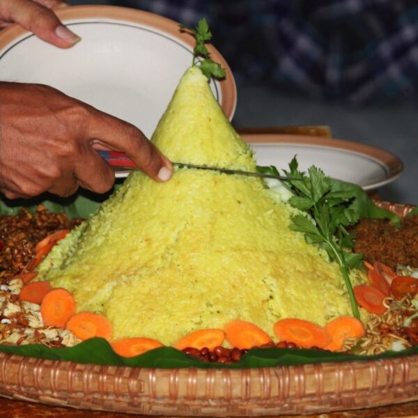 Foto nasi tumpeng khas Banyumas yang lezat, disajikan dengan lauk pauk lengkap dan garnish tradisional, siap untuk dinikmati dalam acara spesial.