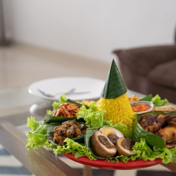 Foto nasi tumpeng khas Banyumas yang lezat, disajikan dengan lauk pauk lengkap dan garnish tradisional, siap untuk dinikmati dalam acara spesial.