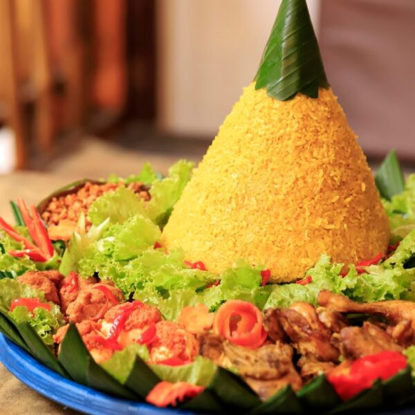 Foto nasi tumpeng khas Banyumas yang lezat, disajikan dengan lauk pauk lengkap dan garnish tradisional, siap untuk dinikmati dalam acara spesial.