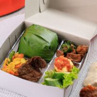 Foto nasi tumpeng khas Tempel yang lezat, disajikan dengan lauk pauk lengkap dan garnish tradisional, siap untuk dinikmati dalam acara spesial.
