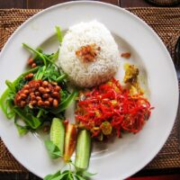 Foto nasi tumpeng khas Sleman yang lezat, disajikan dengan lauk pauk lengkap dan garnish tradisional, siap untuk dinikmati dalam acara spesial.
