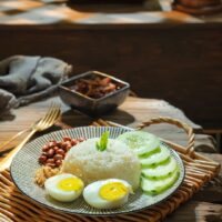 Foto nasi tumpeng khas Pakem yang lezat, disajikan dengan lauk pauk lengkap dan garnish tradisional, siap untuk dinikmati dalam acara spesial.