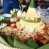 Foto nasi tumpeng khas Petungkriyono yang lezat, disajikan dengan lauk pauk lengkap dan garnish tradisional, siap untuk dinikmati dalam acara spesial.