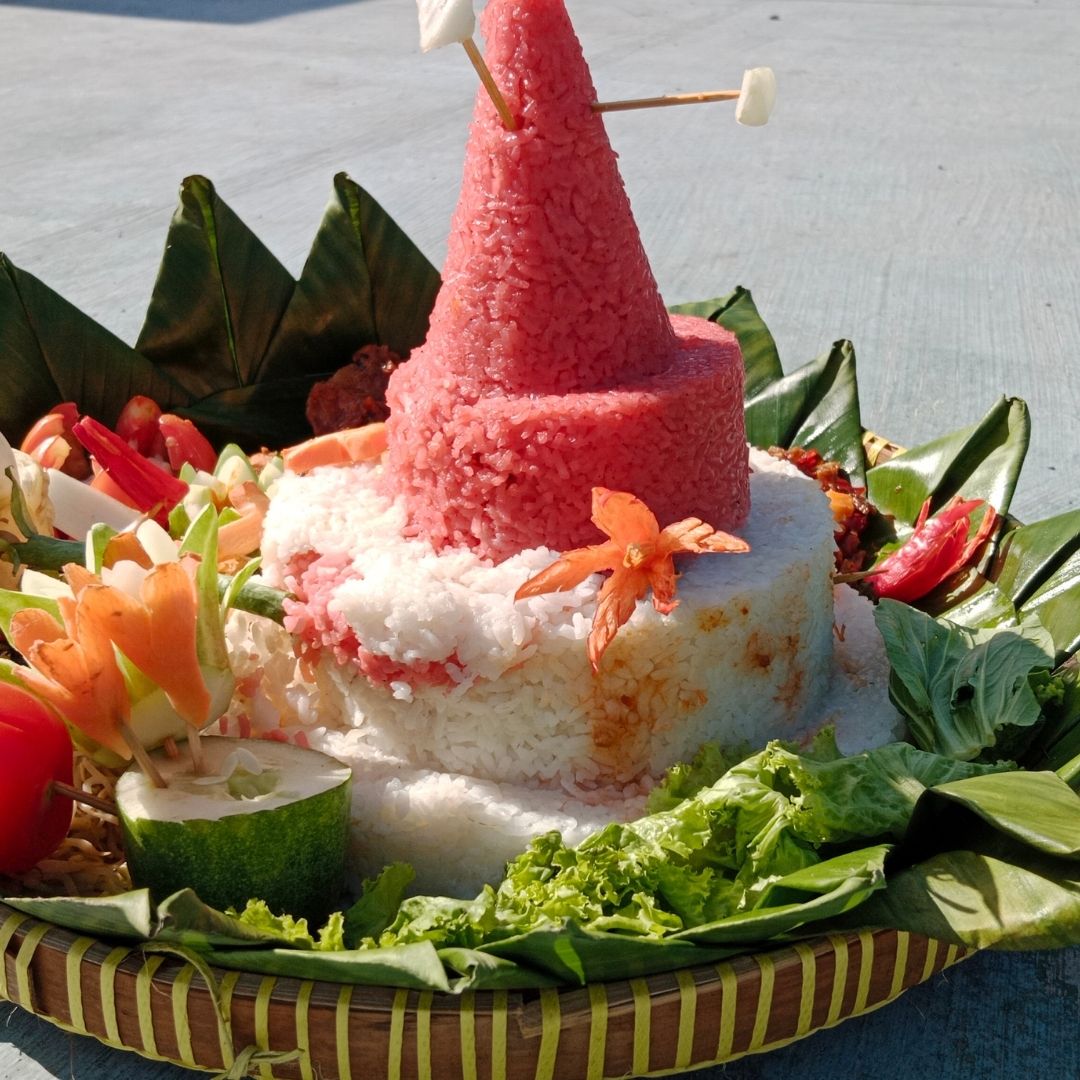 Foto nasi tumpeng khas Sleman yang lezat, disajikan dengan lauk pauk lengkap dan garnish tradisional, siap untuk dinikmati dalam acara spesial.