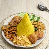 Foto nasi tumpeng khas Samigaluh yang lezat, disajikan dengan lauk pauk lengkap dan garnish tradisional, siap untuk dinikmati dalam acara spesial.