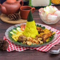 Foto nasi tumpeng khas Depok yang lezat, disajikan dengan lauk pauk lengkap dan garnish tradisional, siap untuk dinikmati dalam acara spesial.