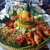 Foto nasi tumpeng khas Paninggaran yang lezat, disajikan dengan lauk pauk lengkap dan garnish tradisional, siap untuk dinikmati dalam acara spesial.