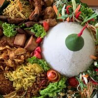 Foto nasi tumpeng khas Dukuhseti yang lezat, disajikan dengan lauk pauk lengkap dan garnish tradisional, siap untuk dinikmati dalam acara spesial.