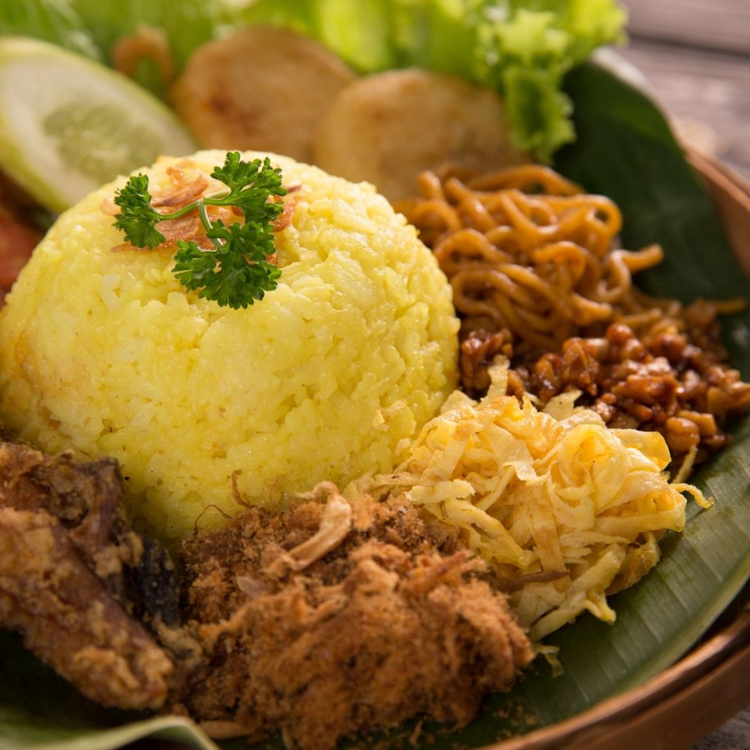 Foto nasi tumpeng khas Purbalingga yang lezat, disajikan dengan lauk pauk lengkap dan garnish tradisional, siap untuk dinikmati dalam acara spesial.