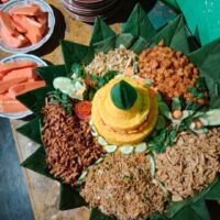 Foto nasi tumpeng khas Kesesi yang lezat, disajikan dengan lauk pauk lengkap dan garnish tradisional, siap untuk dinikmati dalam acara spesial.