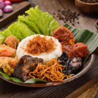 Foto nasi tumpeng khas Ngluwar yang lezat, disajikan dengan lauk pauk lengkap dan garnish tradisional, siap untuk dinikmati dalam acara spesial.