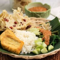 Foto nasi tumpeng khas Muntilan yang lezat, disajikan dengan lauk pauk lengkap dan garnish tradisional, siap untuk dinikmati dalam acara spesial.