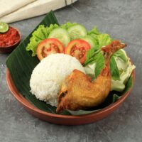 Foto nasi tumpeng khas Bandongan yang lezat, disajikan dengan lauk pauk lengkap dan garnish tradisional, siap untuk dinikmati dalam acara spesial.