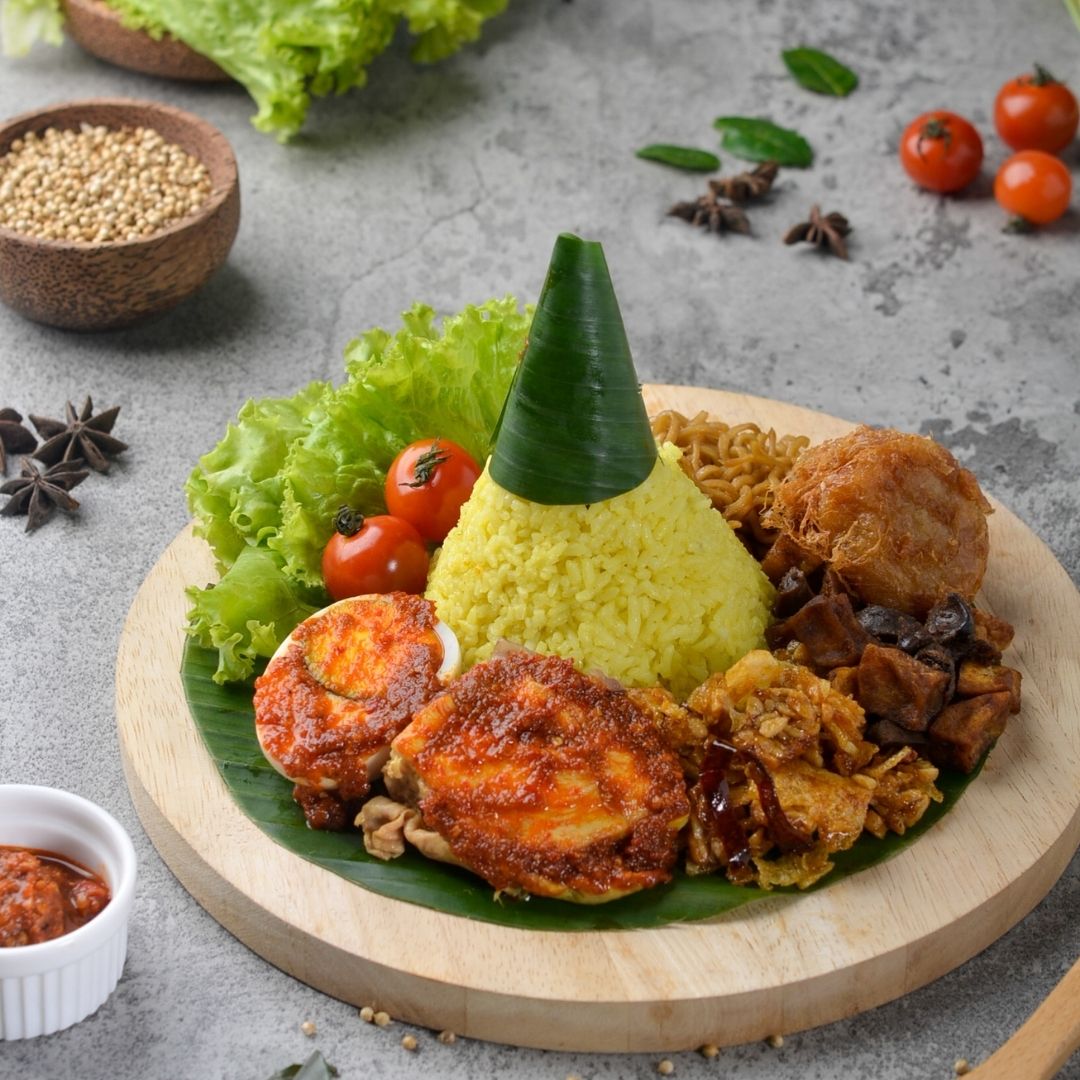 Foto nasi tumpeng khas Belik yang lezat, disajikan dengan lauk pauk lengkap dan garnish tradisional, siap untuk dinikmati dalam acara spesial.