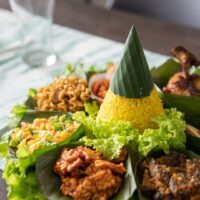 Foto nasi tumpeng khas Toroh yang lezat, disajikan dengan lauk pauk lengkap dan garnish tradisional, siap untuk dinikmati dalam acara spesial.