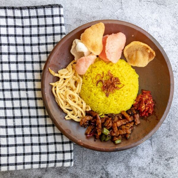 Foto nasi tumpeng khas Grobogan yang lezat, disajikan dengan lauk pauk lengkap dan garnish tradisional, siap untuk dinikmati dalam acara spesial.