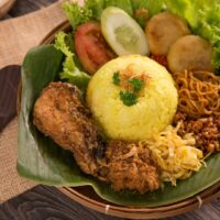 Foto nasi tumpeng khas Sayung yang lezat, disajikan dengan lauk pauk lengkap dan garnish tradisional, siap untuk dinikmati dalam acara spesial.