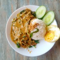 Foto nasi tumpeng khas Wonosalam yang lezat, disajikan dengan lauk pauk lengkap dan garnish tradisional, siap untuk dinikmati dalam acara spesial.