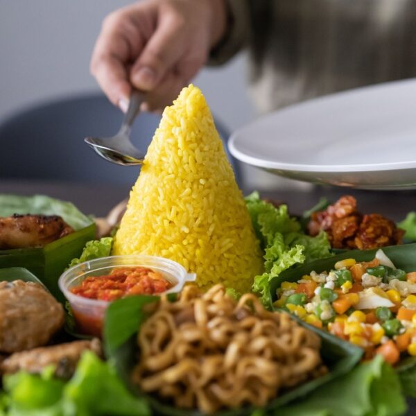 Foto nasi tumpeng khas Demak yang lezat, disajikan dengan lauk pauk lengkap dan garnish tradisional, siap untuk dinikmati dalam acara spesial.